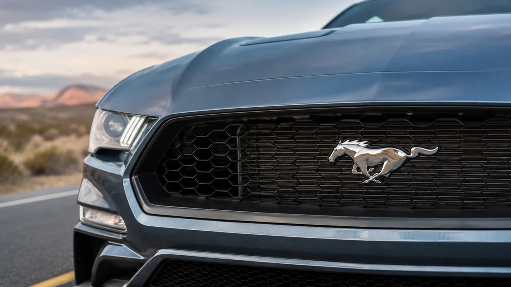 Logo cheval Mustang chromé sur la calandre noire d’une Ford Mustang moderne